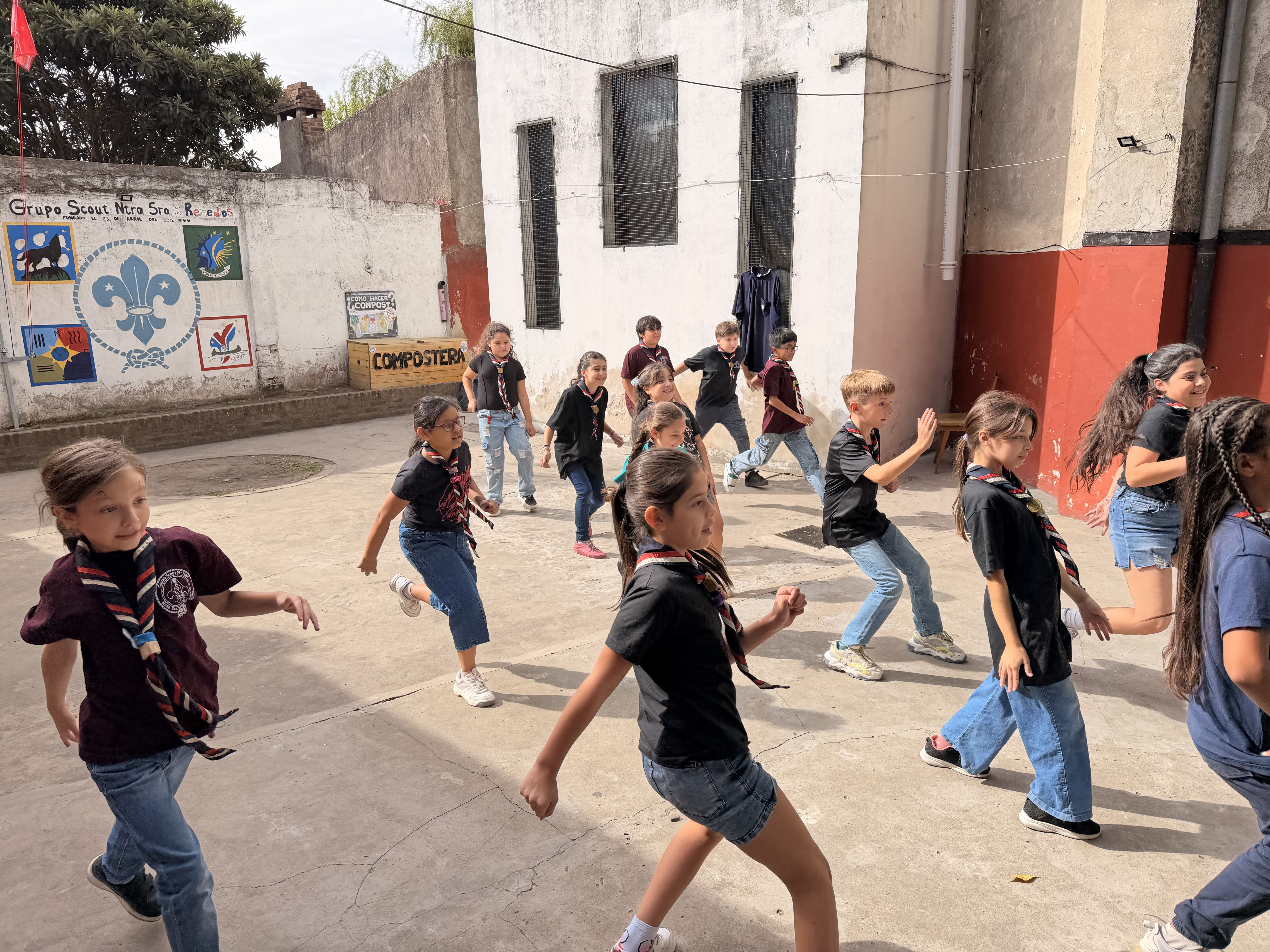 Grupo de niños corriendo en el patio de juegos del grupo.